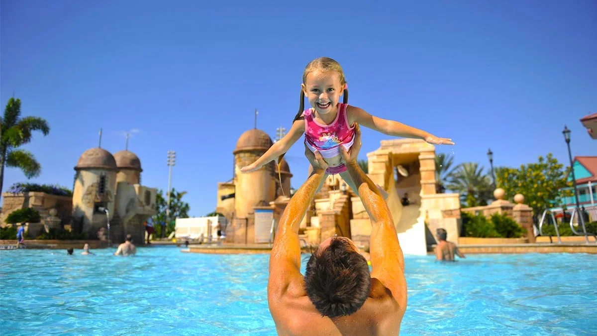 dad holding little girl in pool at the Disney's Caribbean Beach Resort in Orlando, Florida, USA