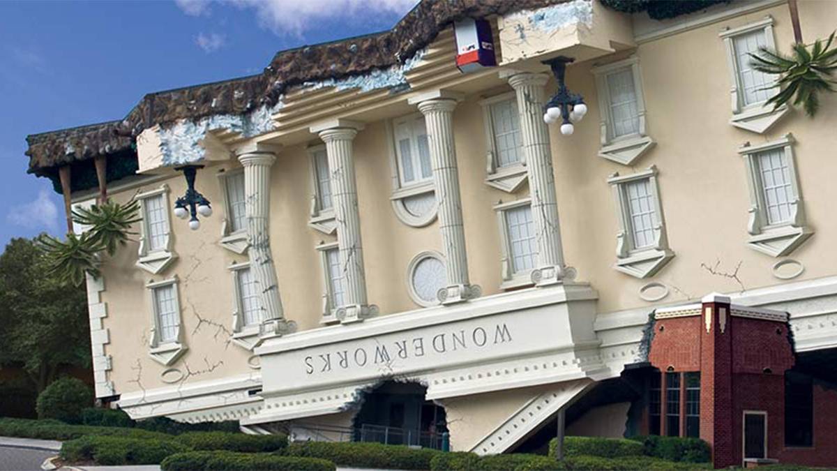 A large building that appears to be upside down serving as the entrance to WonderWorks in Orlando, Florida