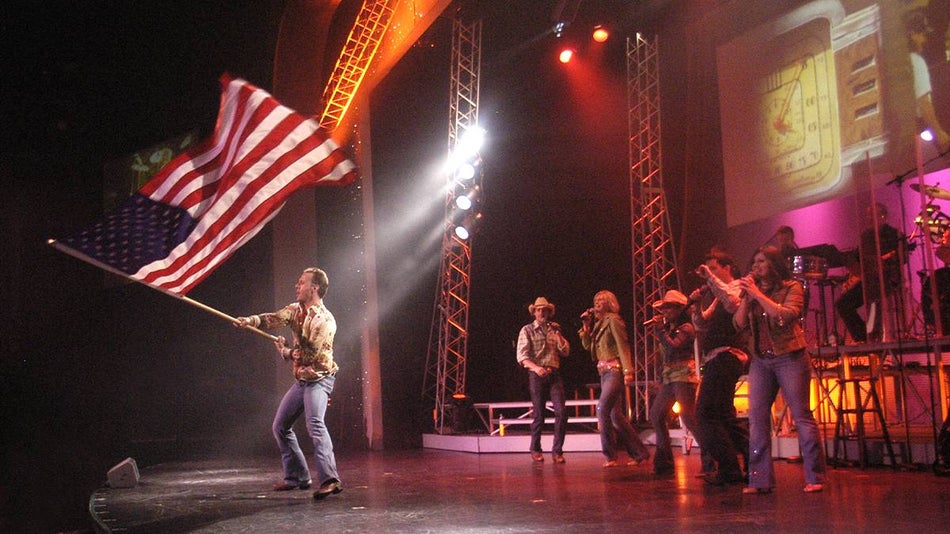 Close up of a concert at Dollywood where a man is waiving an American Flag on stage in Pigeon Forge, Tennessee, USA