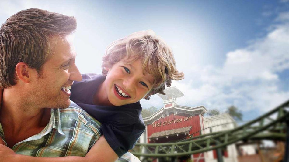 A father holding his son on his back and both of them laughing at Dollywood in Pigeon Forge, Tennessee, USA