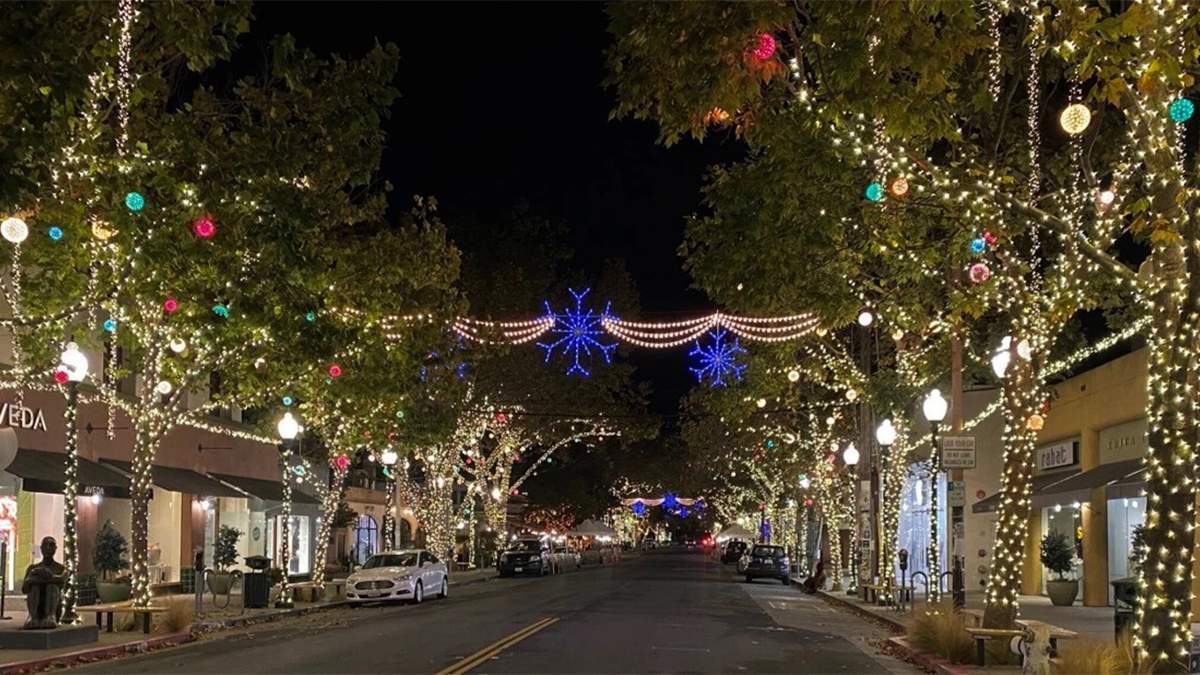 view of street during night with christmas lights and balls hanging on trees at Fourth Street during holidays at San Francisco, California, USA