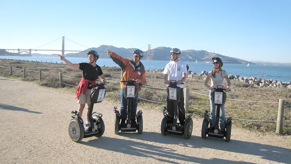 four people on segways standing in front of the Golden Gate Bridge in San Francisco, California, USA