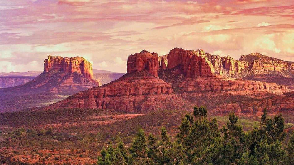 aerial view of red rocks with sunset in background over Sedona, Arizona, USA