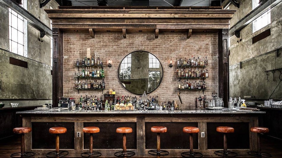 bar in an old factory with a brick wall and barstools
