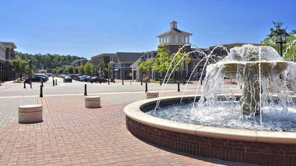 street view of brick and a large fountains with a blue sky in New Town in Williamsburg, Virgina, USA