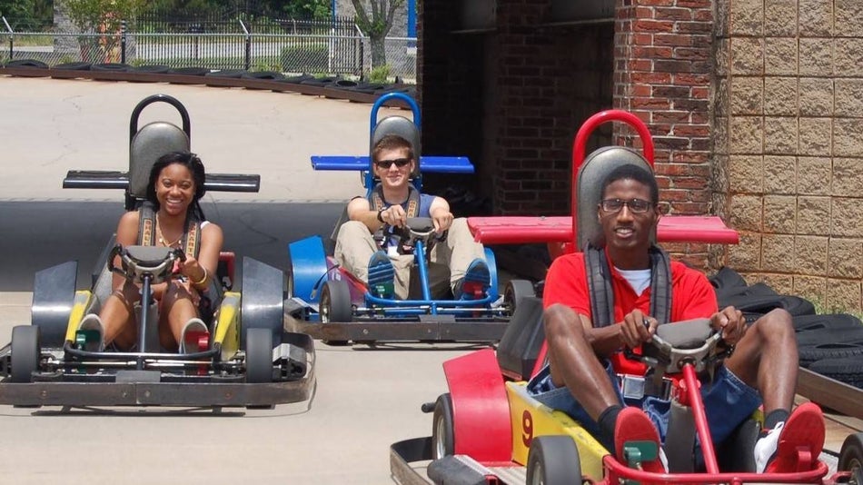 three people sitting on go karts on a track at Fun Spot America Atlanta