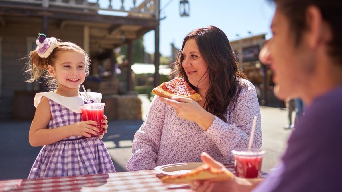 A family enjoys food and drinks at the Boysenberry Festival at Knott's Berry Farm