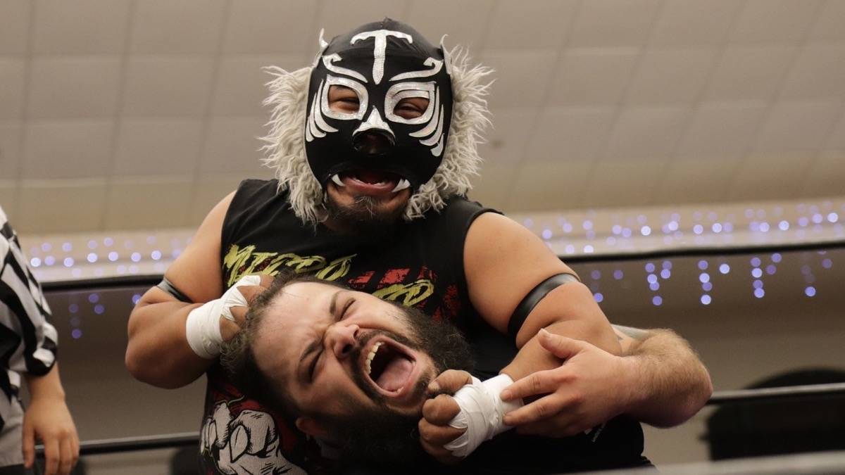 A micro wrestler with a tiger mask putting another wrestler into a headlock