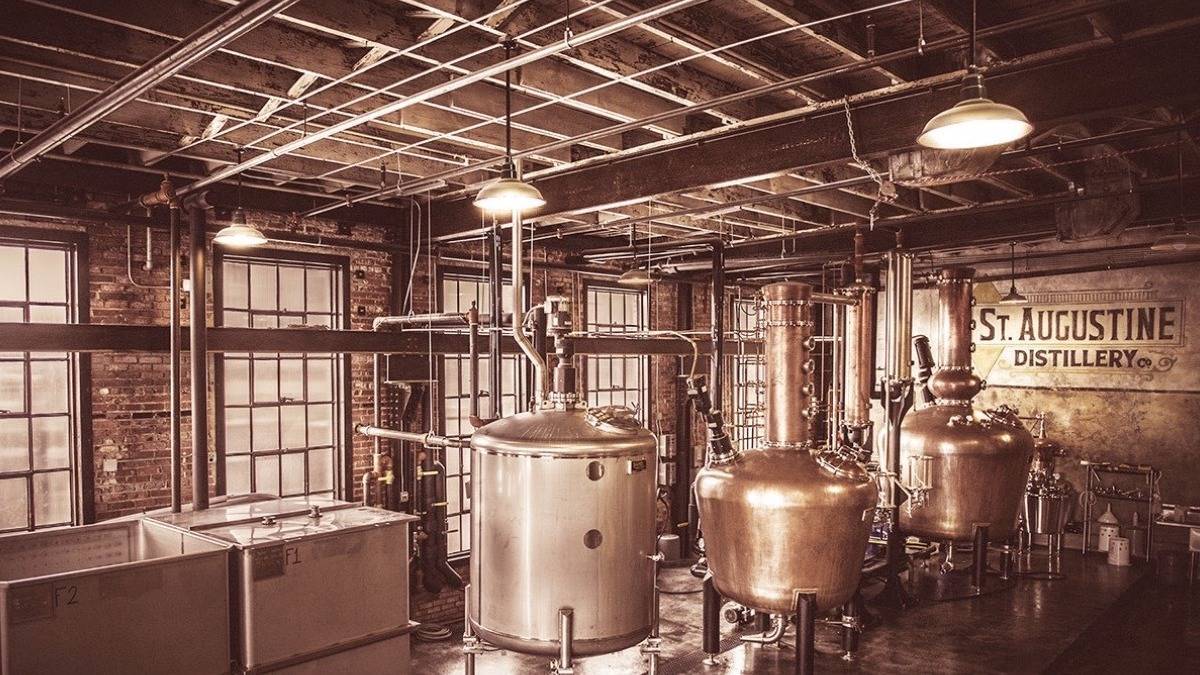 Interior room with brick walls and exposed beams filled with distilling equipment