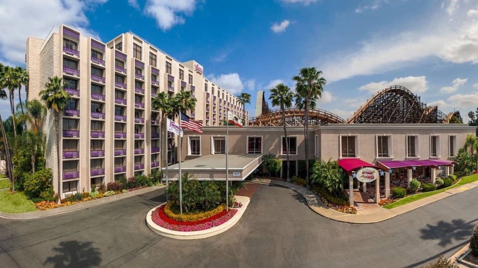 Exterior view of a hotel with a roller coaster in the background