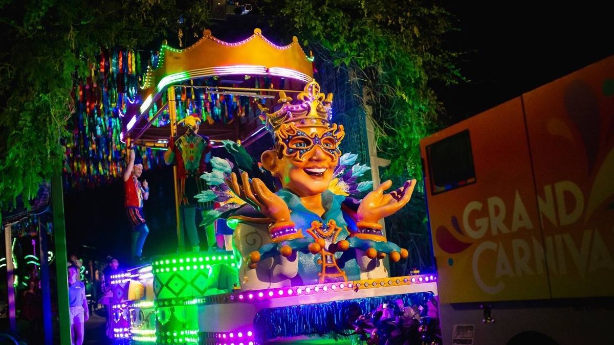 Mardi Gras-themed float with green and purple decorations at Carowinds grand carnivale