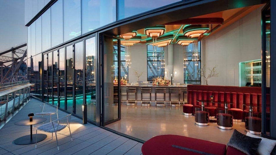 View of rooftop bar with vintage lighting and red accents at dusk