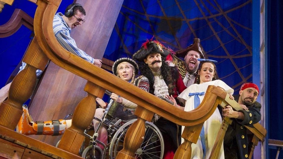 Cast members on a boat looking stressed on the set of Peter Pan goes wrong