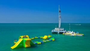 Catamaran in the ocean with a floating play gym nearby