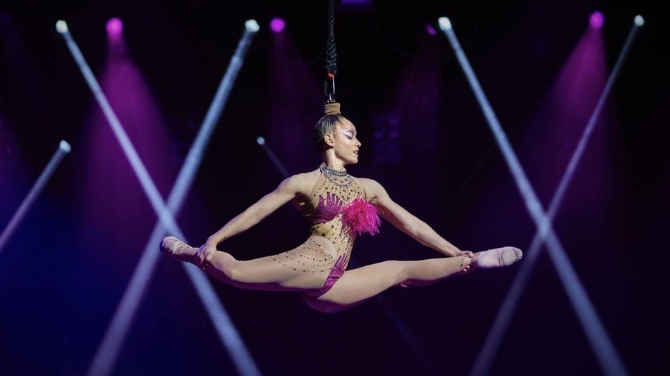 An acrobatic woman held in the air by her ponytail at Mad apple cirque du soleil