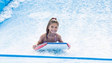 Young girl on a boogie board in on a wave simulator at Myrtle Waves Water Park