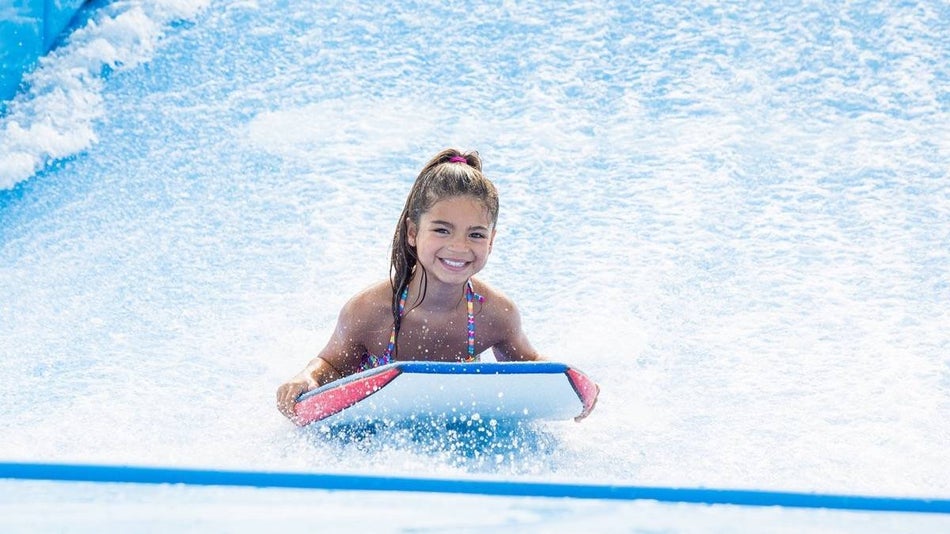 Young girl on a boogie board in on a wave simulator at Myrtle Waves Water Park