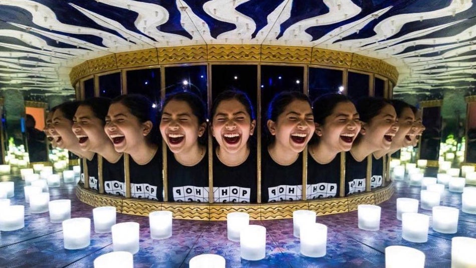Girl laughing in what looks like an illusion of a carousel