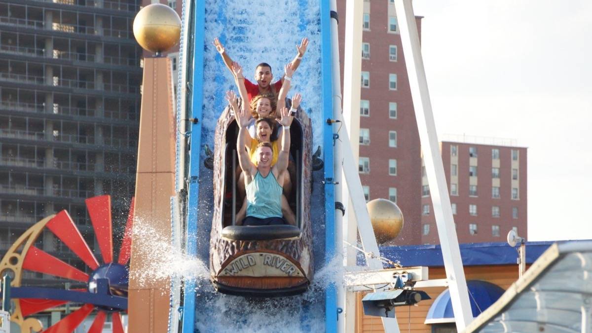 People riding a log flume ride down a waterslide