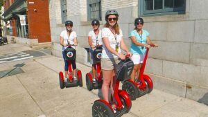Four women on red segways on a sidewalk in philly