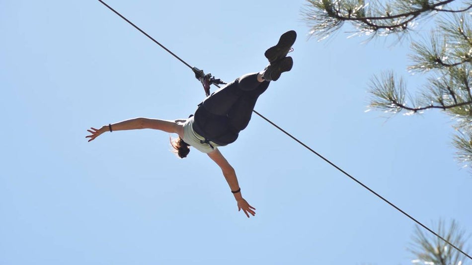 Looking up at a person on a zipline