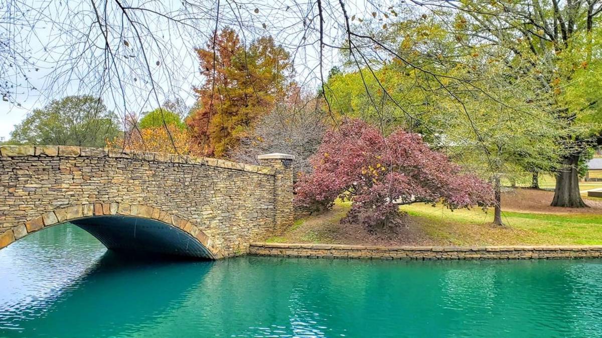 Stone bridge over a lake with fall foliage in the background