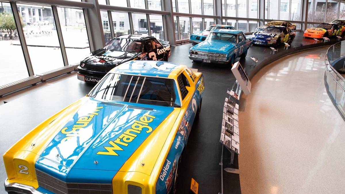 A loop of nascar vehicles inside the nascar hall of fame in Charlotte