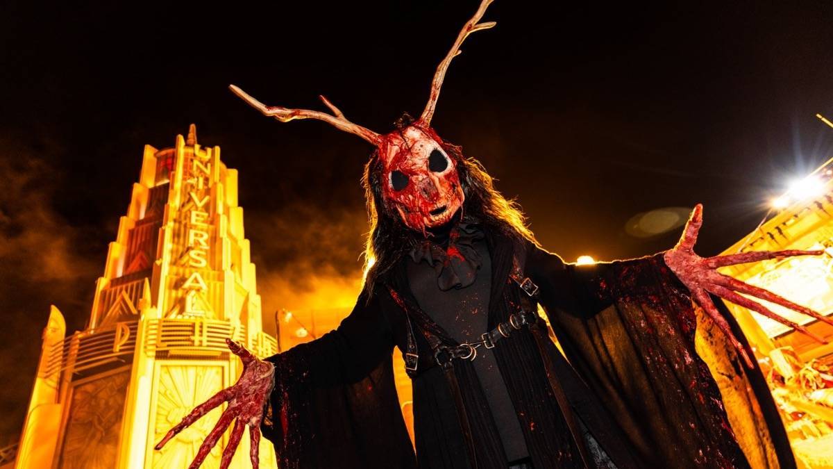 Very tall scary looking scare actor with horns and a bloodied animal face in a black robe