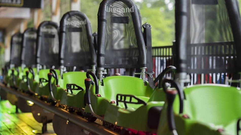 Wide shot of green and black roller coaster chairs