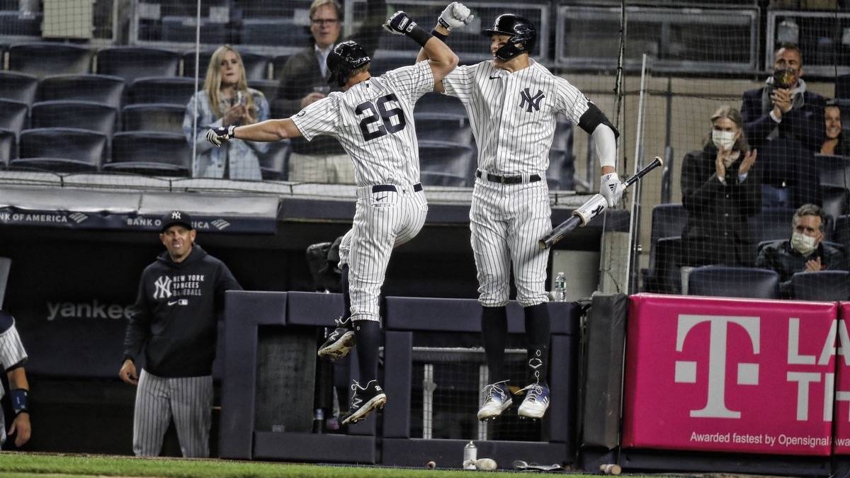 Two new york yankees players jumping up and celebrating by hitting elbows