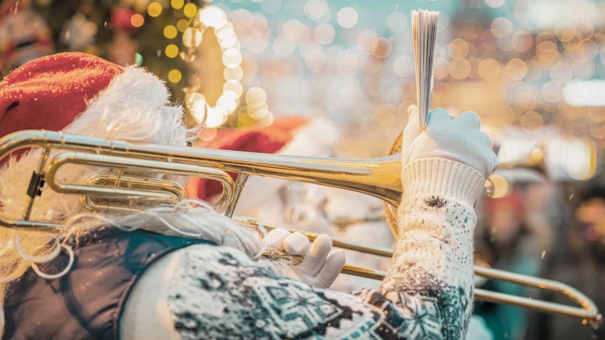 Santa in a sweater playing a trombone