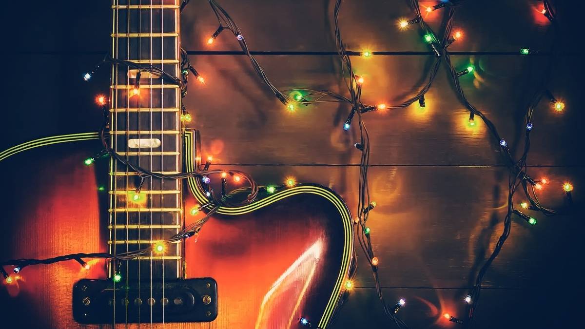 Closeup of a guitar with christmas lights strung around it