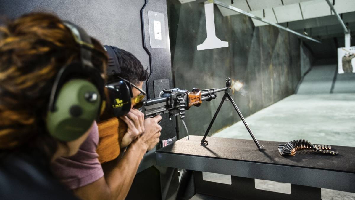 A man shooting a rifle at a paper in a gun range