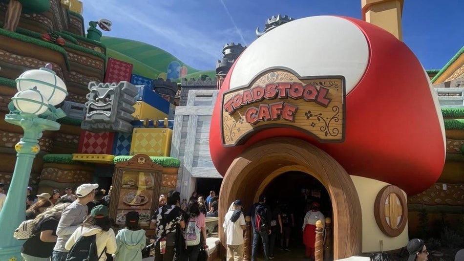 Exterior view of Toadstool cafe, a red and white mushroom in a mario world cartoon setting