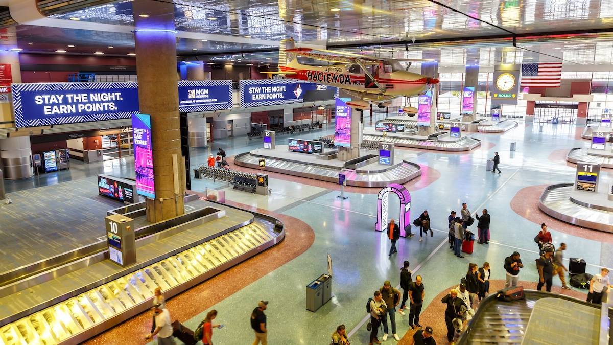 Interior shot of the baggage claim at the Las Vegas airport with a small plane hanging from the ceiling