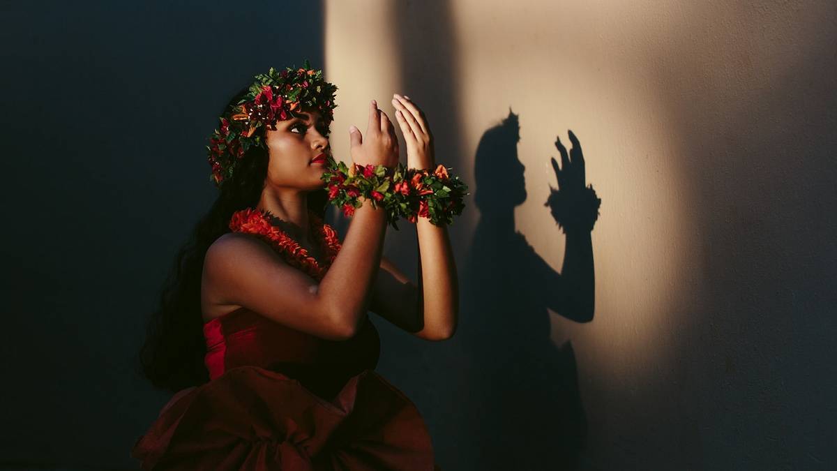 A girl with hawaiian flower leis around her head adn wrists