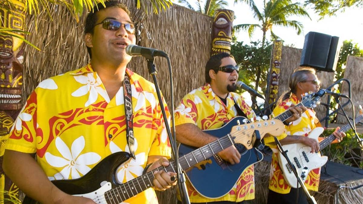 Three hawaiian performers singing and playing guitar