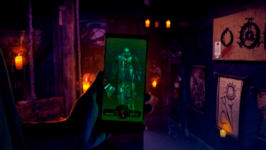 Hand holding a phone with a ghostly figure showing on the screen holding an axe