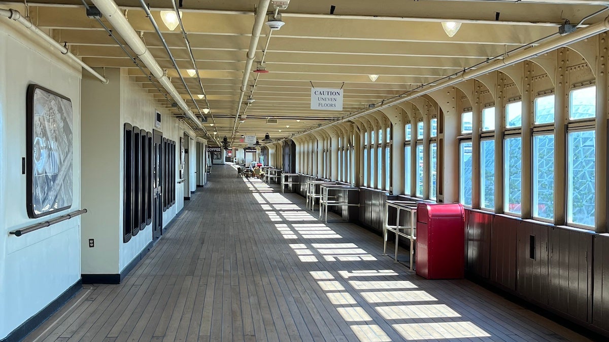Interior deck with wooden floors and white metal walls of the Queen Mary