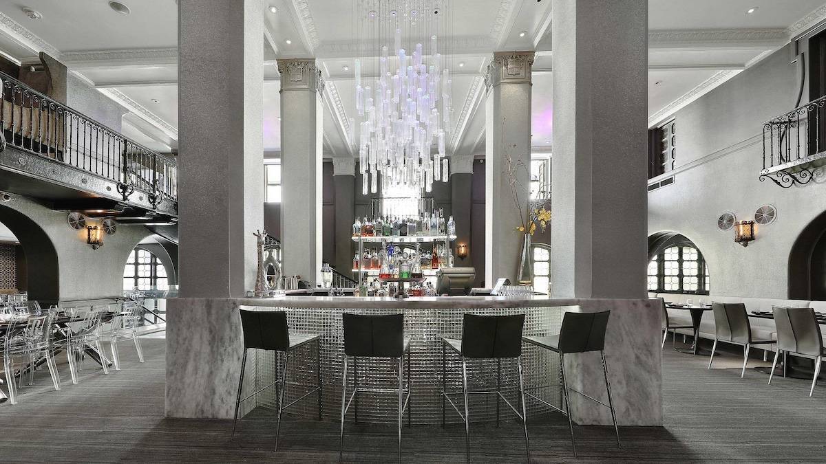 White and grey sleekly decorated restaurant with a bar in the middle