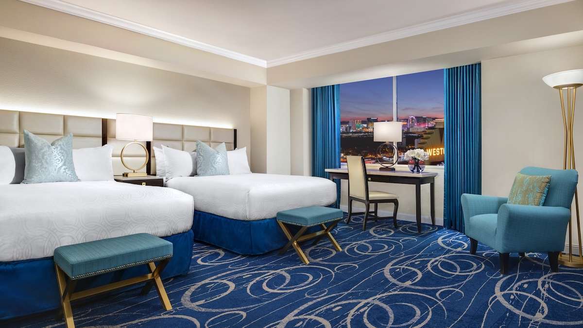 Interior room at the westgate in las vegas, with two beds and blue carpet and blue and gold accents