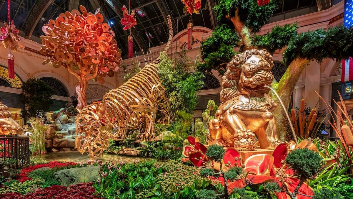 Interior lush garden with gold asian statues of a tiger and a dragon