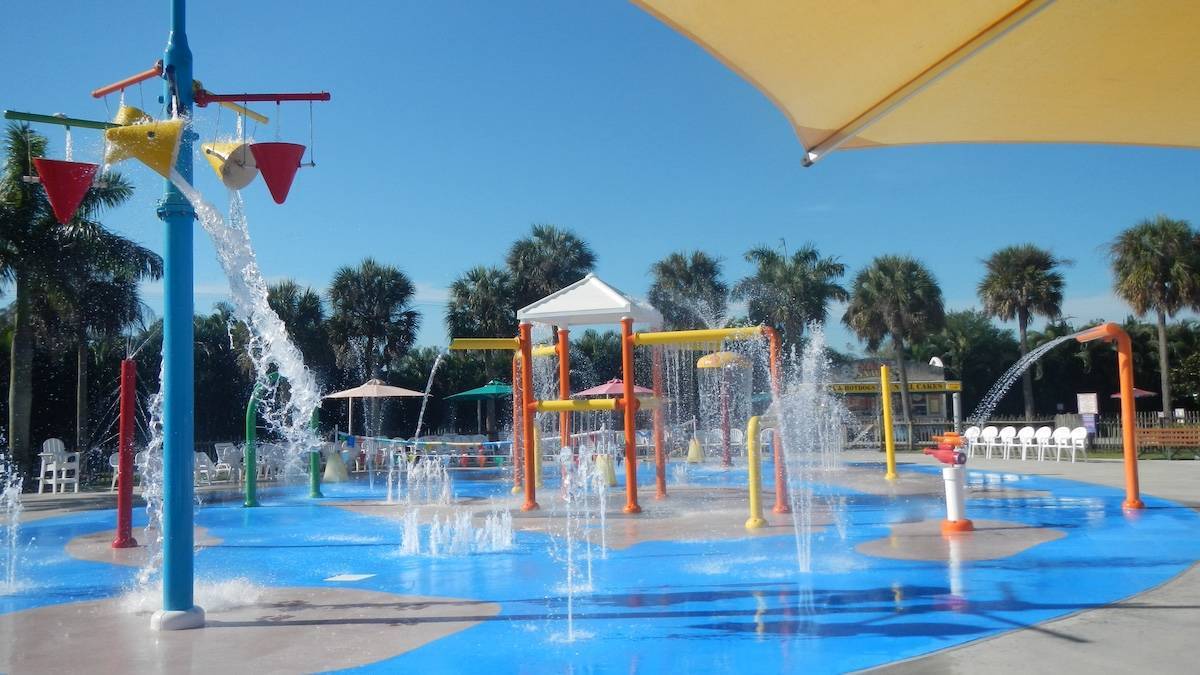 A large splash pad water park with buckets dumping water onto the ground