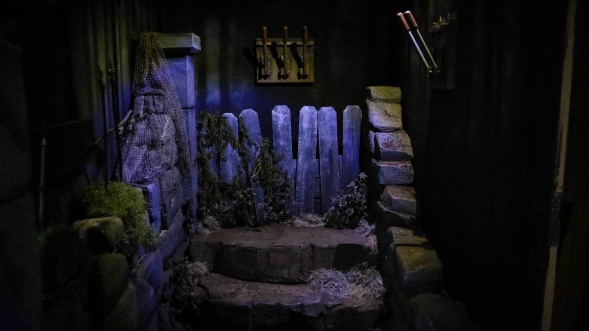 Dimly lit room with a some stone steps and hooks on the wall