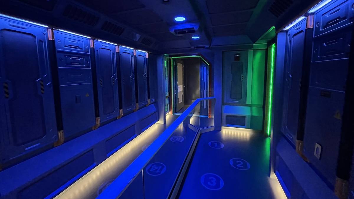 Interior staging room lit with blue and green lights for Avatar Flight of Passage