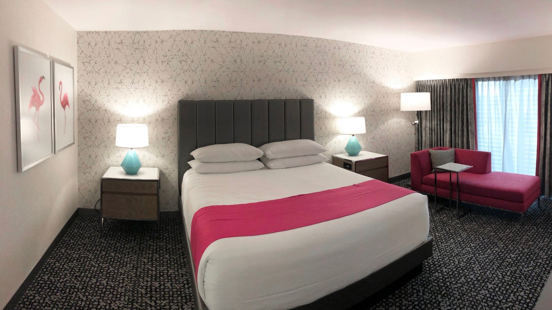 Interior shot of a hotel room with white and pink decor