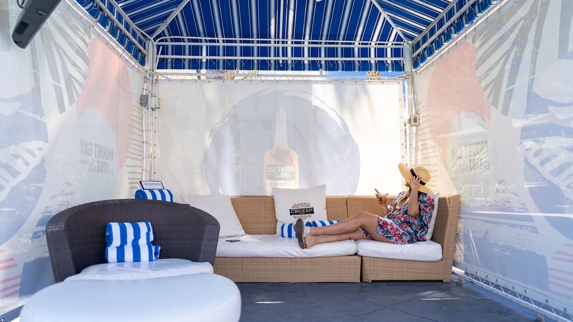 Woman sitting on a white couch under a cabana
