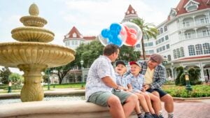 a family sitting on the fountain of Disney Grand Floridian Resort & Spa