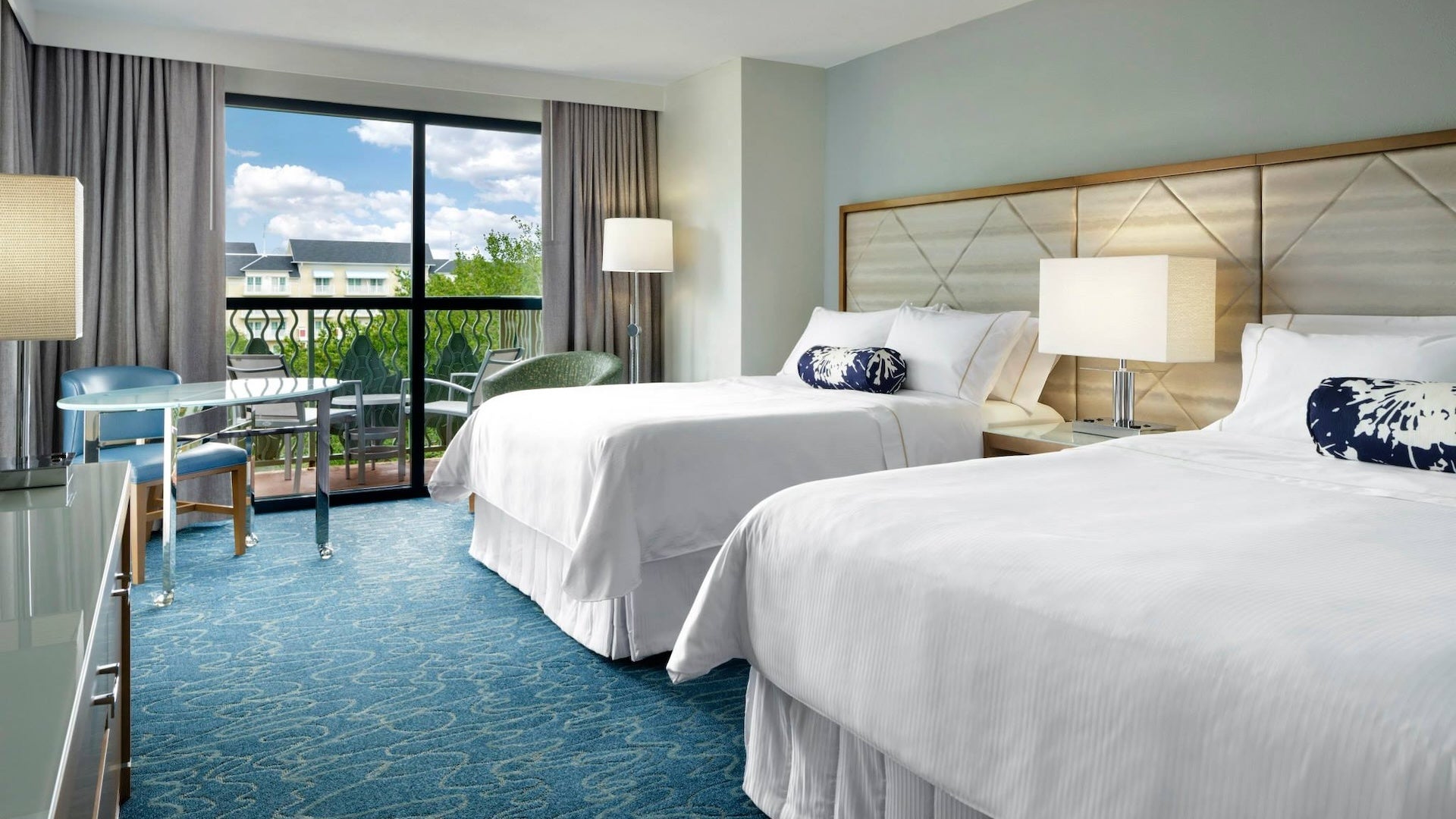 two rooms with blue carpet and a balcony at Walt Disney World Swan and Dolphin