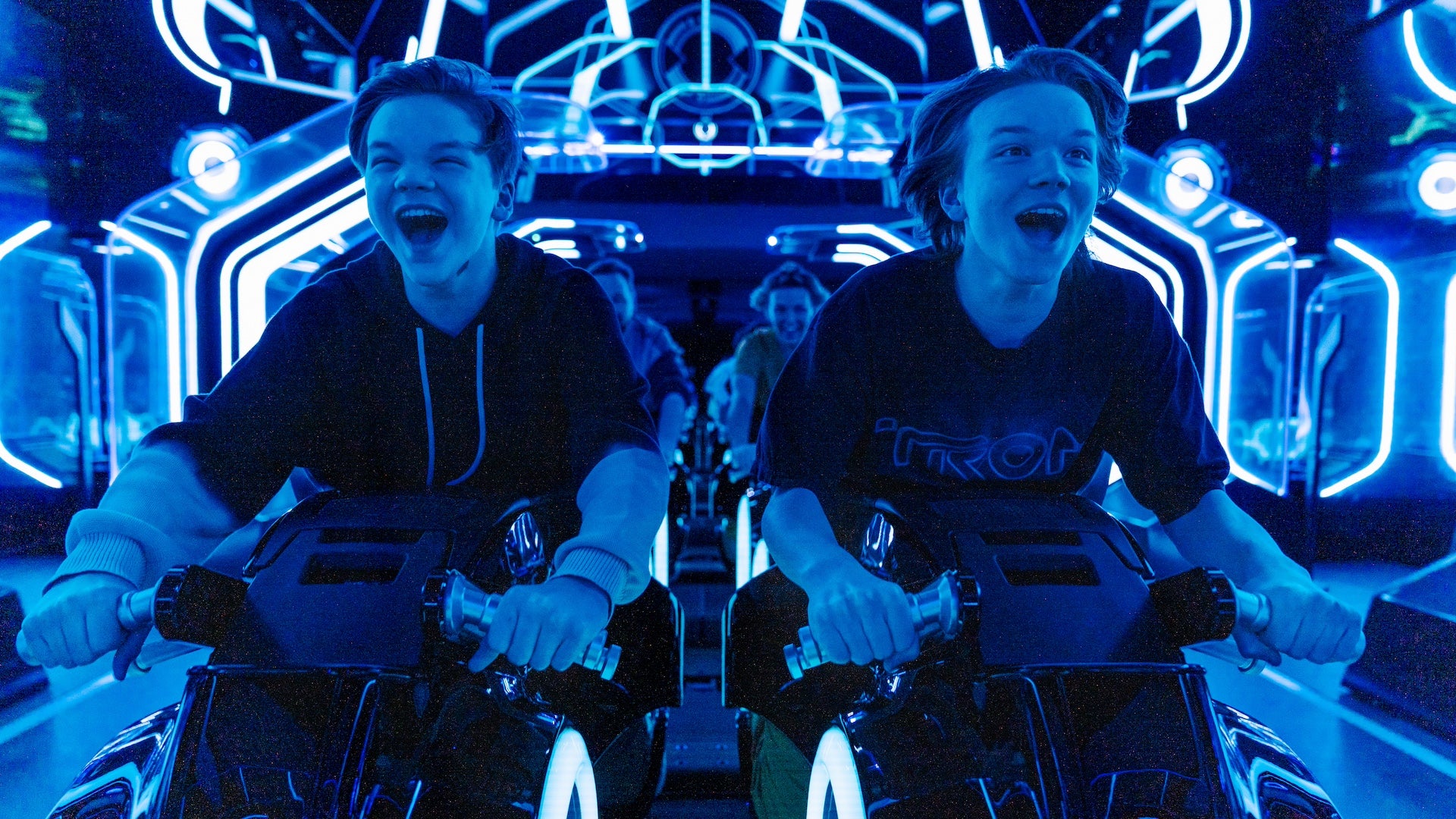 Up close shot of two boys inside the Tron ride about to take off